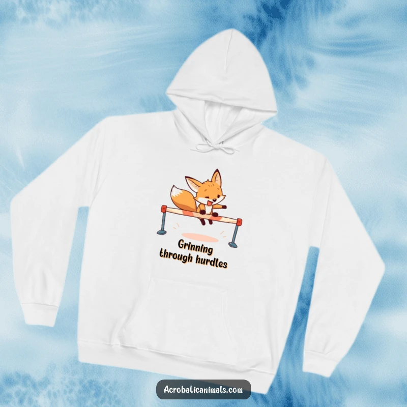 Funny fox hoodie showing a determined fox with a wide grin leaping over a hurdle, blending ambition with cozy warmth.