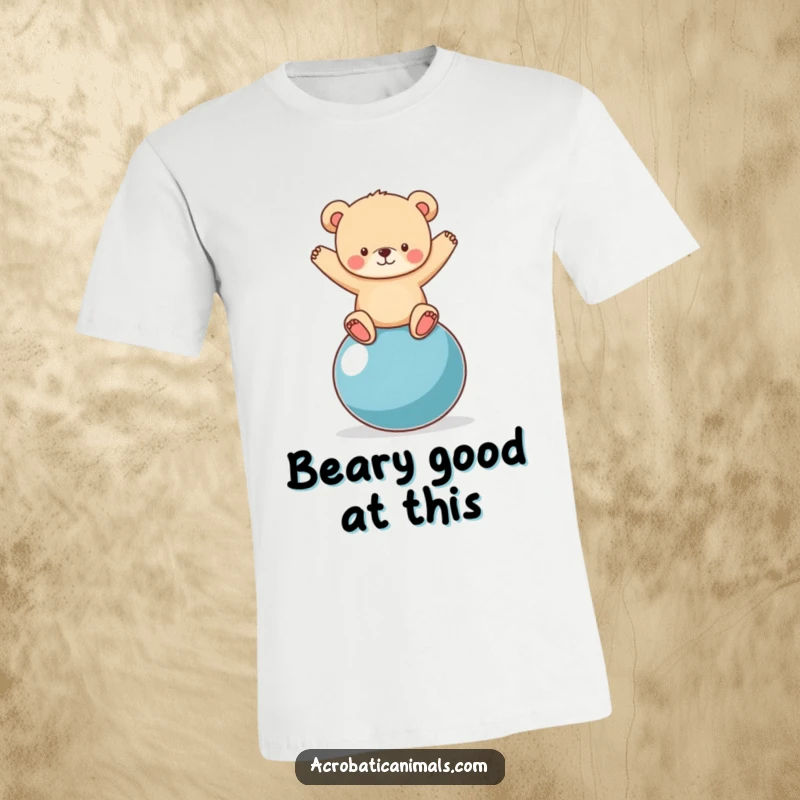 Funny bear cub adorably struggling yet succeeding to balance on a giant yoga ball, printed on a comfy t-shirt.